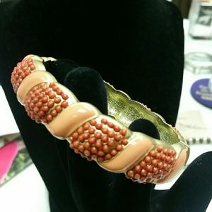 Gold tone and coral enamel bangle.